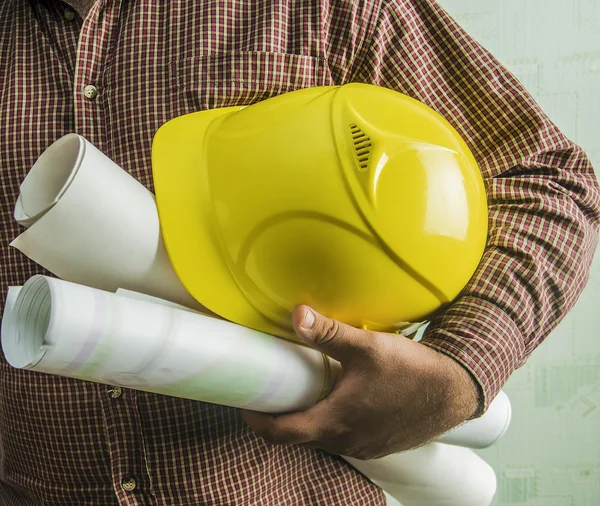 Engenheiro segurando plantas e capacete — Fotografia de Stock