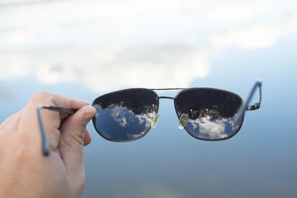 Hand innehav svarta solglasögon — Stockfoto