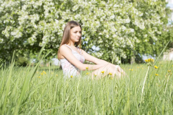 在一片草地上坐的女人 — 图库照片