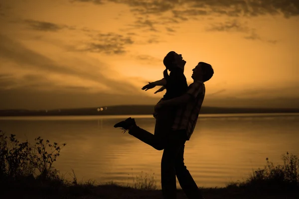 Silhouette Eines Paares Mann Hält Frau Gegen Sonnenuntergang — Stockfoto