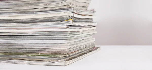 Stapel tijdschriften op witte tafel — Stockfoto