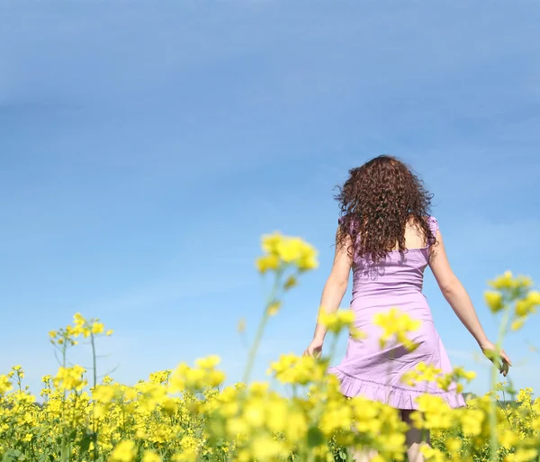 Žena chůze na květinové pole — Stock fotografie