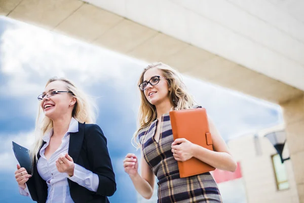 Two  businesswomen walking on the street near office building