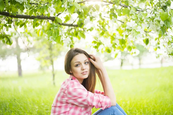 Girl sitting down under tree Stock Picture
