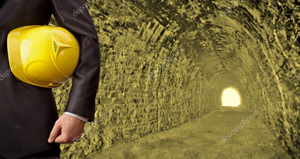 Businessman holding yellow helmet