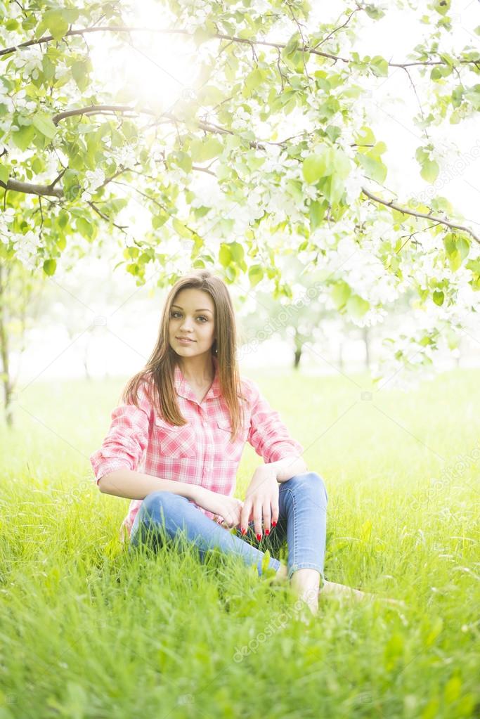  girl sitting down under tree