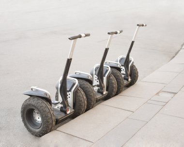 Bir asfalt yolda Segways 