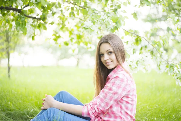 Flicka sitter under träd — Stockfoto