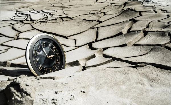 Relógio em solo seco rachado — Fotografia de Stock