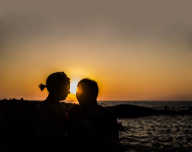 Sunset beach adlı oturan çiftin siluetleri