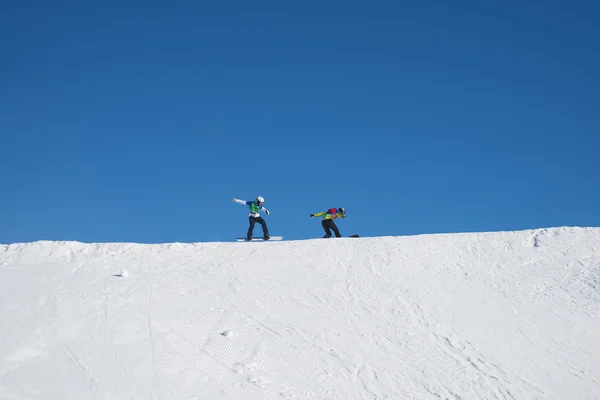 Сноубордисты спускаются с горы — стоковое фото