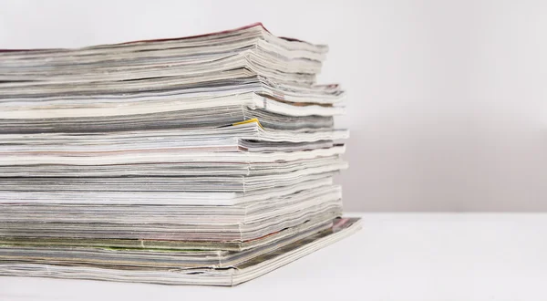 Stapel tijdschriften op witte tafel — Stockfoto