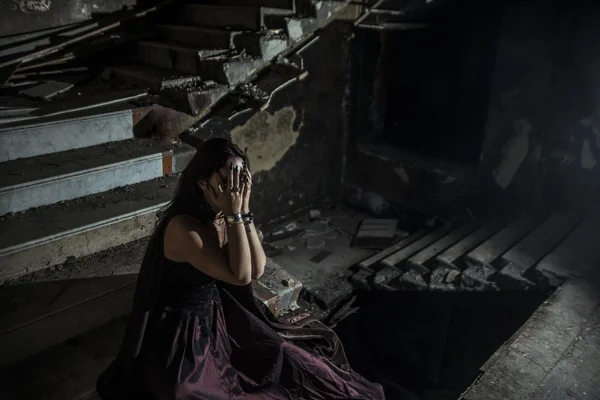 Photo Jester Woman Holding Hands Face While Sitting Dark Stone — Stock Photo, Image