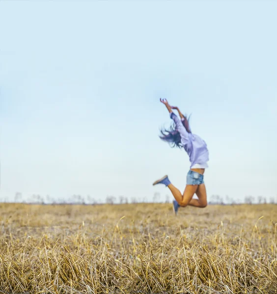 Mujer saltando en el campo . — Foto de Stock