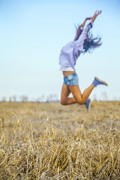 woman jumping in agriculture field.