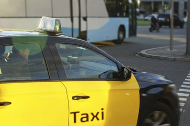 Sarı taksi mavi otobüsün yanında. Otobüs ya da taksi. Şehir ulaşımı ve araç seçimi konsepti. BARCELONA, İSPAN