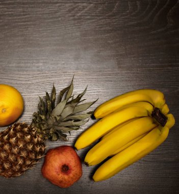 Bir ananas, greyfurt, nar ve taze muz. Üst Manzara. Siyah ahşap masa arka planı. Boş kopya alanı. sıra sağlıklı yiyecekler