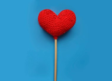 Kırmızı yün kalp mavi arka planda izole edilmiş. Sevgililer günün kutlu olsun..