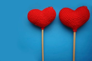 Mavi arka planda iki kırmızı yünlü kalp. Sevgililer günün kutlu olsun..