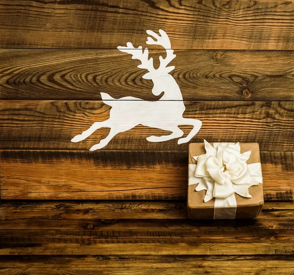 白鹿画在木板上 礼品盒用手工纸包好 新年快乐 圣诞快乐 假日背景 — 图库照片