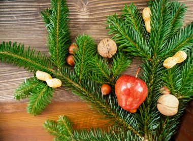 Koyu ahşap arka planda farklı fındıkları olan Noel ağacı dalları. Mutlu Noeller ve mutlu yıllar 2021.