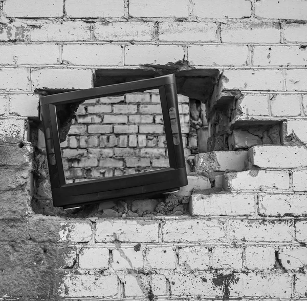The old TV set inserted into a hole in the wall
