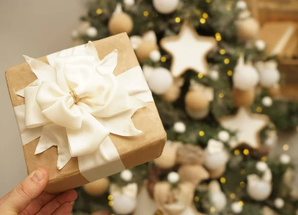 Mão Masculina Segurando Caixa Presente Perto Abeto Natal Fundo Wal — Fotografia de Stock