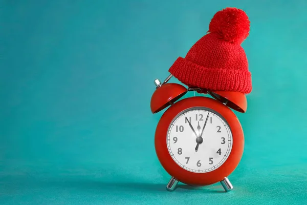 Kırmızı Örgü Şapkalı Minyatür Alarm Saati Kağıtta Izole Edilmiş Tatil — Stok fotoğraf