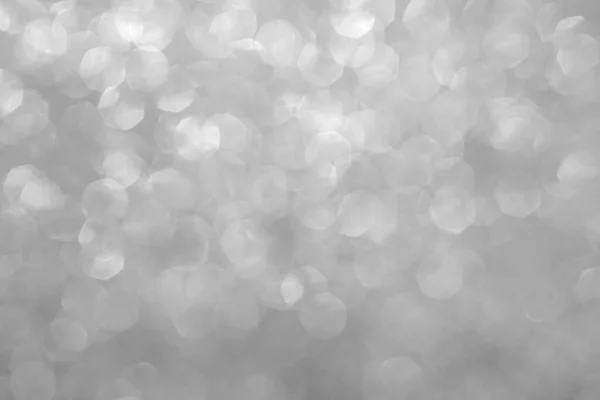 Abstract grey silver blur background. Silver Festive Christmas background. Abstract twinkled bright background with natural bokeh defocused white lights. Holiday party backdrop with blurry special magic effect