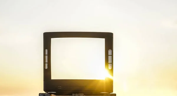 body of old vintage tv stands against the backdrop of sunny forest, wild nature and sunset light. no kinescope