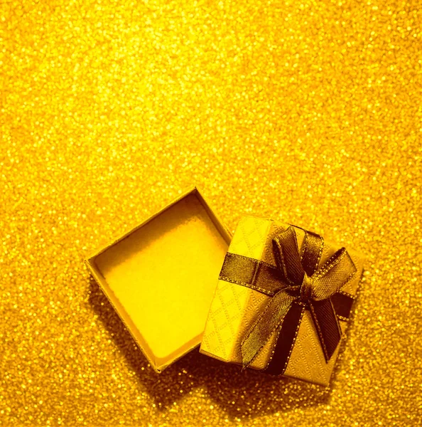 打开空白的黄色礼品盒 在金色的桌子上系上褐色缎带弓 顶视图 重点不突出的背景 — 图库照片