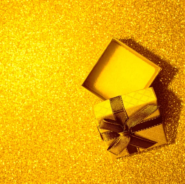 打开空白的黄色礼品盒 在金色的桌子上系上褐色缎带弓 顶视图 重点不突出的背景 — 图库照片