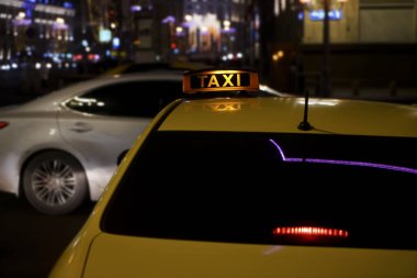 Şehir caddesinde akşam ya da gece taksi durağında sarı taksi tabelası. Moskova, Rusya.