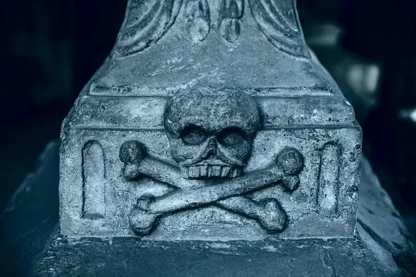 頭蓋骨と十字架の骨が墓石に刻まれています — ストック写真