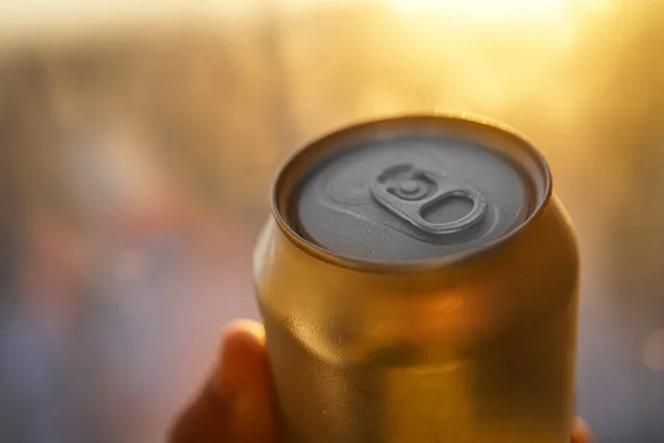 golden Can of beer close up at sunny day. Fresh drink at warm day. Metallic can with cold drink. Alcohol drink. wet surface.