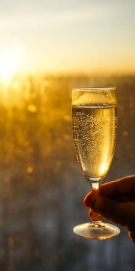 Erkek el ele tutuşup bir bardak şampanya yakıyor. gün batımı altın gökyüzü arkaplanı.