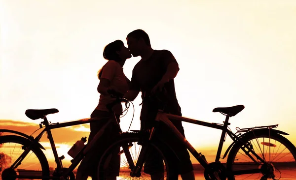 Günbatımında Bisiklete Binen Çift Kıyı Şeridi Boyunca Öpüşen Çiftlerin Silueti — Stok fotoğraf