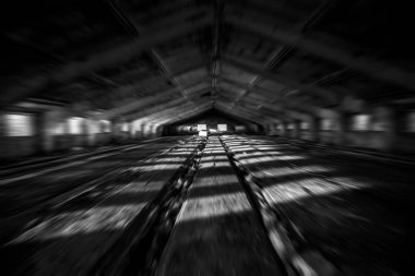 Bulanık görüntü. Terk edilmiş eski ahır tuğlası bina çatısı sızdırıyor ve güneş ışığında iç duvarlar yıkılıyor.