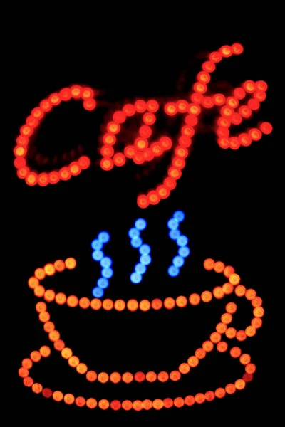 模糊的图像在漆黑的夜晚 咖啡店里 一只咖啡杯的标牌闪烁着光芒 — 图库照片