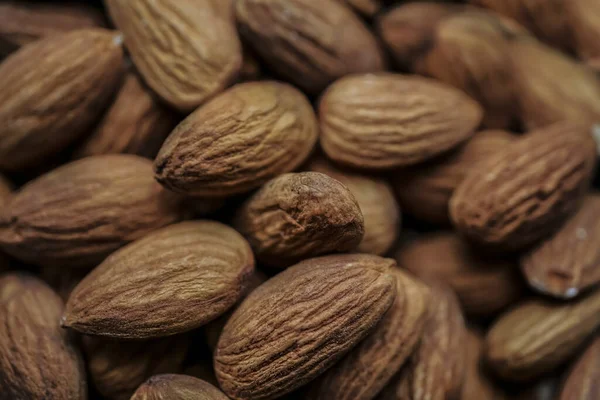 Background of big raw peeled almonds situated arbitrarily. tasty almond nuts closeup background