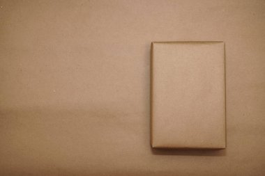Kraft kağıdına sarılı bir kutu. El işi kâğıdı üzerine izole edilmiş. Yazı için boş kopyalama alanı.