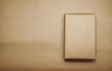 Kraft kağıdına sarılı bir kutu. El işi kâğıdı üzerine izole edilmiş. Yazı için boş kopyalama alanı.
