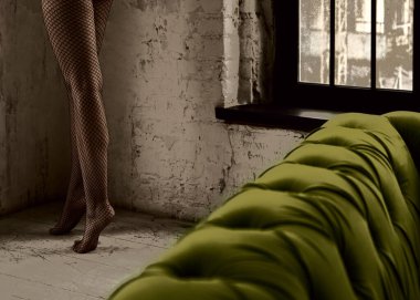 Siyah dantelli file taytın detaylı görüntüsü. Duvarda şık taytlı bir kadın figürü var..