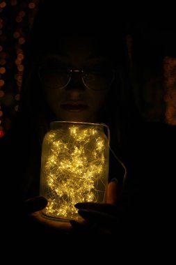 El ele tutuşan bir kadın, tatilde bir bardakta hafif bir çelenk taşıyordu.