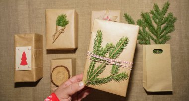 Çam dalları, hediye kutuları, çuval bezi arka planda. Mesaj için yer var. Üst Manzara. Düz yatıyordu. 2021 mutlu yıllar. Noel kompozisyonu