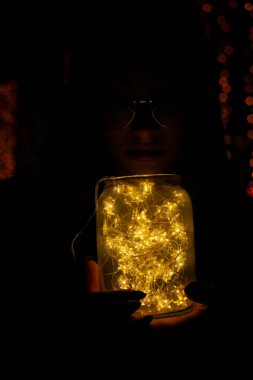 El ele tutuşan bir kadın, tatilde bir bardakta hafif bir çelenk taşıyordu.