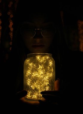 El ele tutuşan bir kadın, tatilde bir bardakta hafif bir çelenk taşıyordu.