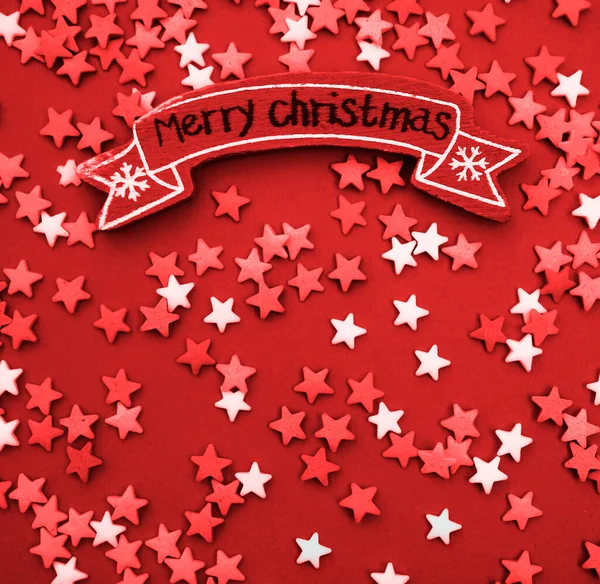 许多五彩斑斓的星星上挂着节日的问候和圣诞的装饰 圣诞快乐 红色的圣诞节背景 红木标牌 — 图库照片