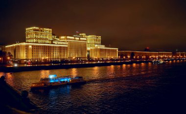 Rusya Savunma Bakanlığı 'nın panoramik manzarası, Novoandreevsky Köprüsü, Moskova. Gece sahnesi. Tekne Moskova nehrinde yol alıyor.