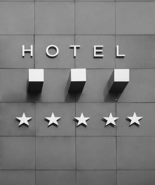 golden Board or signboard for a five stars hotel. 5 star hotel signage board. Wall of a building with a sign for a hotel with star declaration clipart